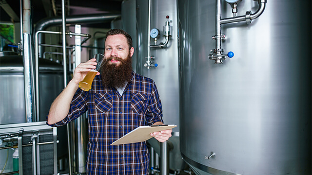 bearded man with a beer glass craft brewing