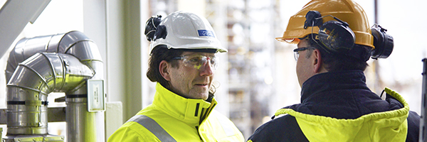 Workers discussing at oil refinery